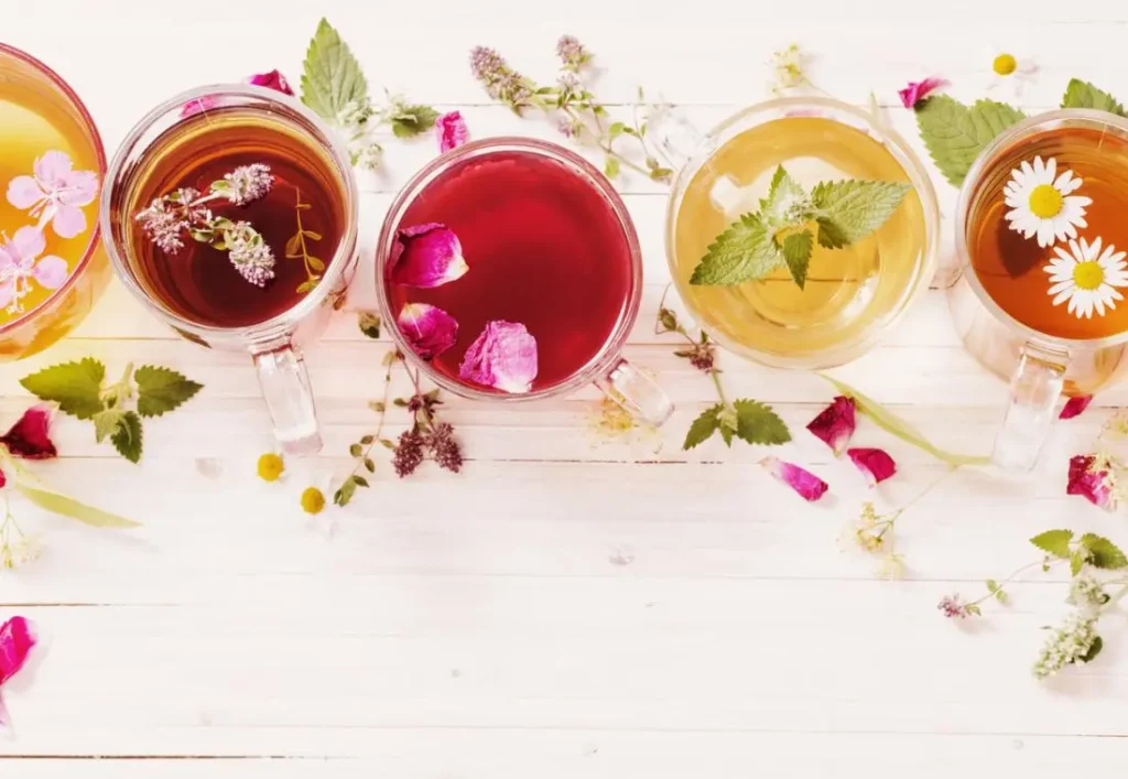 five cups of herbal teas in a row including rosehip nettle and dandelion tea